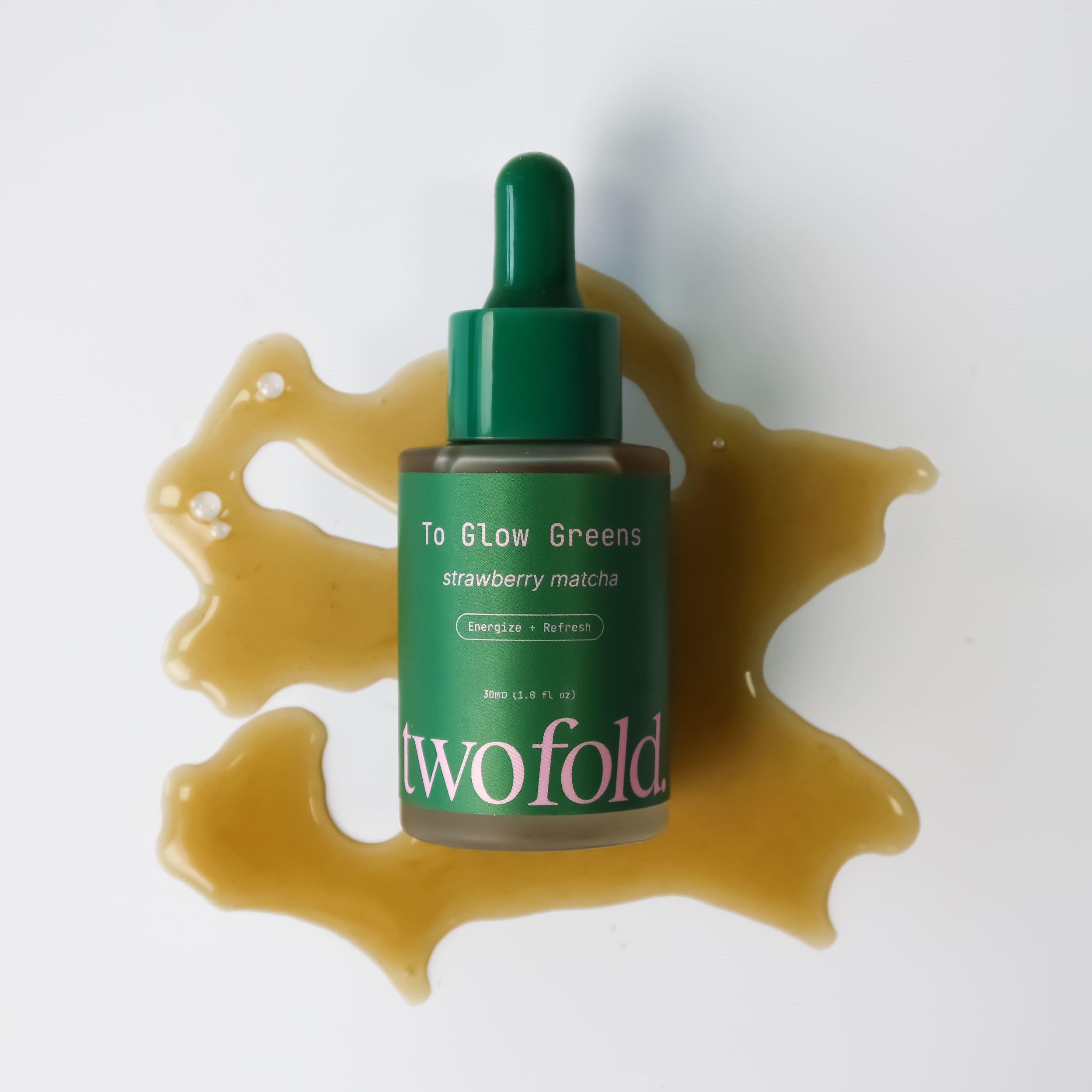 Green skincare product bottle with dropper on a white background